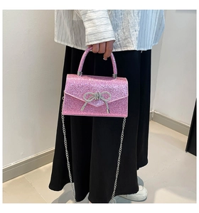 Détail macro du tissu pailleté rose et boucle élégante en strass argentés en nœud
