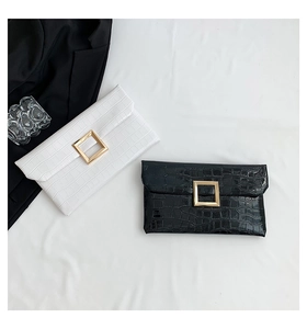 Detail of stone pattern envelope clutches with large gold buckles in black and white