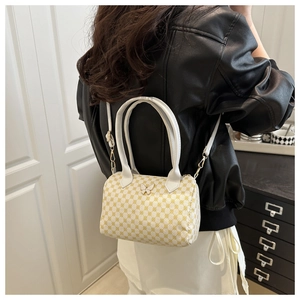 Model showing butterfly crossbody bag with yellow checkered pattern in a home setting