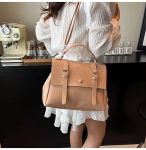 Vue détaillée d'un sac messager vintage beige avec doubles boucles et sangle