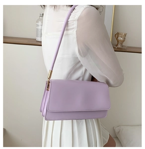 Close-up of lavender leather shoulder bag with gold hardware and minimal flap design