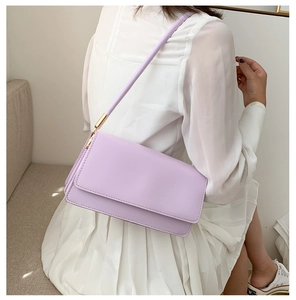 Detail view of a lilac rectangle shoulder bag featuring a sleek flap and gold hardware