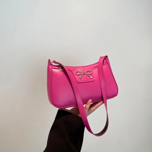 Pink crescent underarm bag with a golden bow buckle in minimalist French fashion style