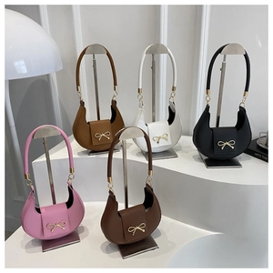 Detail view of various colored crescent handbags with elegant golden bow-knot buckle