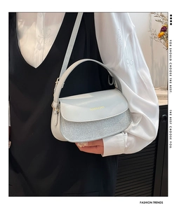 Makro-Detail der hellblauen Lederhandtasche mit Silberglitzer und Logo aus Metall