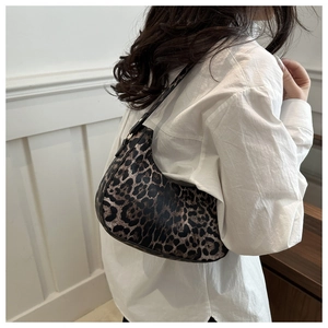 Détail du sac hobo à imprimé léopard avec bandoulière réglable et chemise blanche