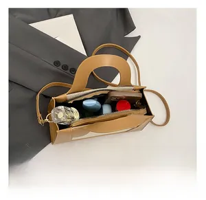 Vue de dessus montrant l'intérieur spacieux du sac à bandoulière marron pour les essentiels