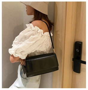 Chic black leather rectangular shoulder bag with golden hardware and flap closure design