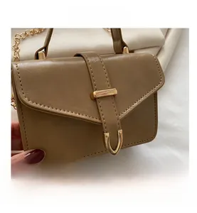 Close-up of khaki PU leather bag with golden U-shaped buckle and fine stitching detail