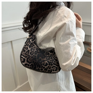 Gros plan du sac hobo à imprimé léopard avec bandoulière noire et boucle dorée chic
