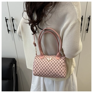 Detail of pink retro pillow bag with monogram print and butterfly buckle on model