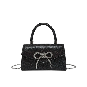 Elegant black sequin evening handbag with silver bow detail and metallic chain strap