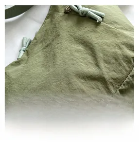 Detail of pea green fabric texture and neat stitching on a large commuter crossbody bag