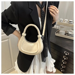 Dettaglio della borsa a mezzaluna beige con scritta FASHION e fibbia in metallo