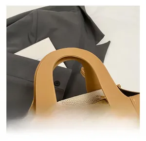 Détail du sac à main en toile et cuir avec fermeture éclair dorée et poignée surpiquée