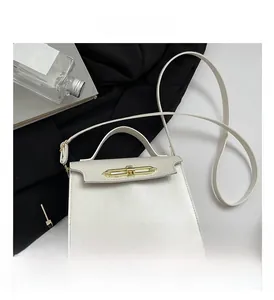 Detail of white leather handbag featuring gold horizontal clasp and structured top handle