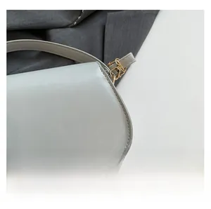 Nahaufnahme der hellgrauen Ledertasche mit feiner Textur und goldener Metallschnalle