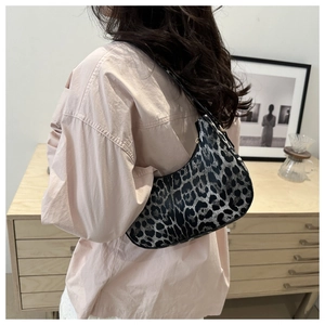 Sac croissant à motif léopard porté par un mannequin dans un intérieur élégant