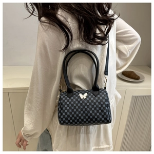 Rear view of a chic black Boston bag with blue floral print and butterfly detail
