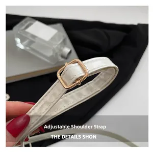 Detail of white PU leather bag featuring adjustable strap and elegant gold metal buckle