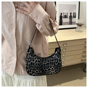 Détail du sac hobo léopard montrant la forme en croissant et les ferrures dorées