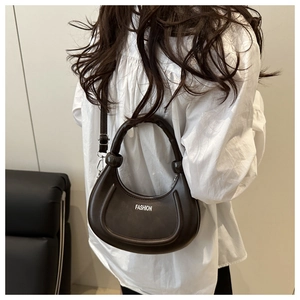 Dettaglio borsa hobo marrone scuro con scritta FASHION e fibbia in metallo sulla tracolla