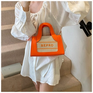 Detail of a square tote bag featuring orange leather and woven fabric with BEPRO logo