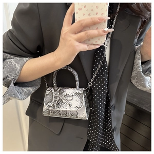 Chic black and white snakeskin mini bag with silver butterfly buckle and chain strap