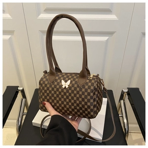 Macro view of vintage monogram Boston bag featuring a 3D butterfly charm and gold hardware