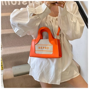 Detail of trendy orange and beige square bag with BEPRO embroidery and shoulder strap