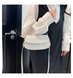 Detail of white leather and silver shimmer patchwork flap bag with thin strap