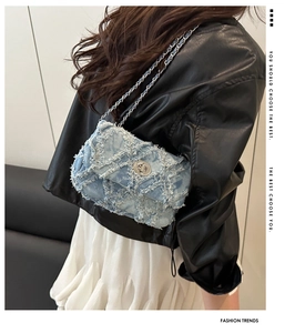 Détail du sac à bandoulière en denim bleu clair avec franges et bandoulière chaîne