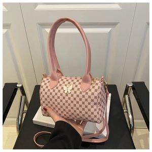 Close-up of pink pillow bag with vintage geometric patterns and butterfly metal buckle