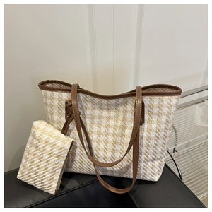 Detail of checkered tote and pouch set with brown leather handles and classic weave