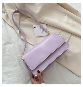 Detail of lavender flap shoulder bag with gold metal accents and sleek leather texture