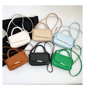 Vista plana de bolsos bandolera pequeños en varios colores con cierres dorados mate