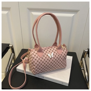 Detailed close-up of pink Boston bag with floral texture and 3D butterfly ornament