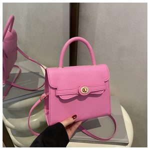 Detail view of the pink leather handbag featuring a secure golden turn-lock closure