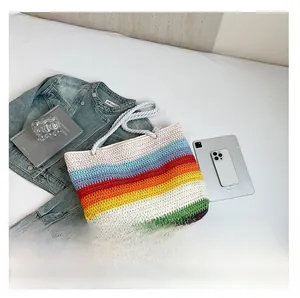 Détail de sac cabas tissé à rayures arc-en-ciel avec anse en corde blanche robuste
