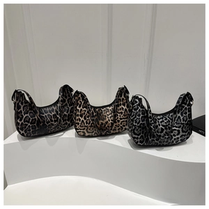 Trois variantes de sacs hobo en forme de croissant à motif léopard sur socles blancs