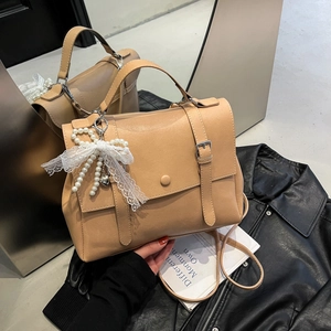Sac messager vintage camel en similicuir avec un nœud en dentelle et perles en studio