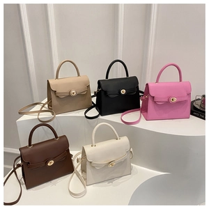 Five assorted vintage crossbody bags in khaki, black, pink, and cream on a display stand
