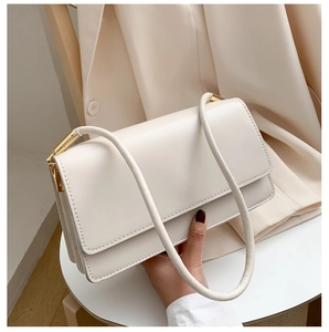 Detail of cream white PU leather shoulder bag featuring gold buckle and magnetic flap closure