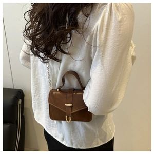 Detailed back view of vintage brown leather crossbody bag with gold chain strap