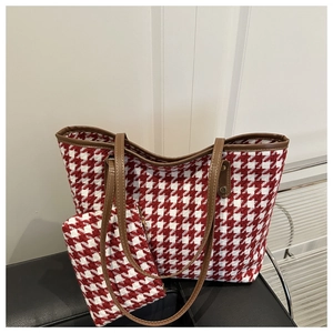 Detail of red and white houndstooth tote bag with brown leather handles and matching pouch