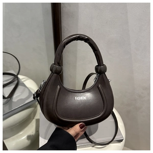 Dettaglio della borsa a mezzaluna marrone scuro in pelle PU con manico superiore