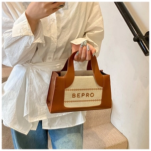 Detail of beige canvas tote with brown leather trim and BEPRO embroidered text
