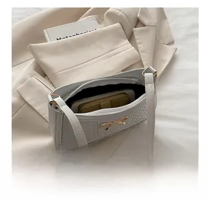 Vue de dessus d'un sac à bandoulière tressé crème montrant l'intérieur spacieux pour mobile