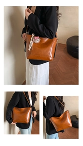 Detail of caramel oil wax leather tote bag with teddy bear charm and large storage capacity