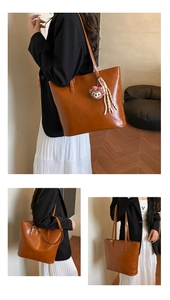 Detail of vintage brown large tote bag in faux leather with plush charm decoration